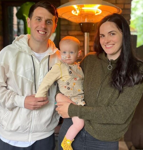 Natassia and Matthew standing and holding their son Brooklyn